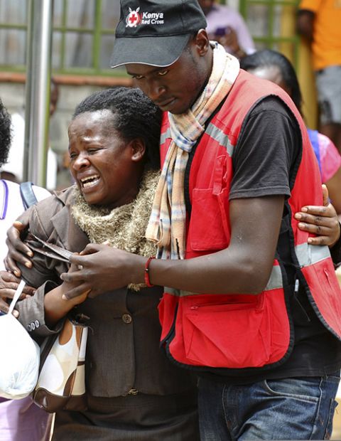 A Red Cross worker assists a grieving relative April 3, 2015, as bodies of Garissa University College students killed the previous day arrive at a mortuary in Nairobi, Kenya. Al-Shabab militants raided the campus, leaving at least 147 dead. (CNS/Reuters)