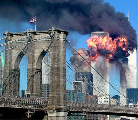 Both towers of the World Trade Center in New York City burn after planes crashed into them Sept. 11, 2001. In the foreground is the Brooklyn Bridge. (CNS/Reuters/Sara K. Schwittek)
