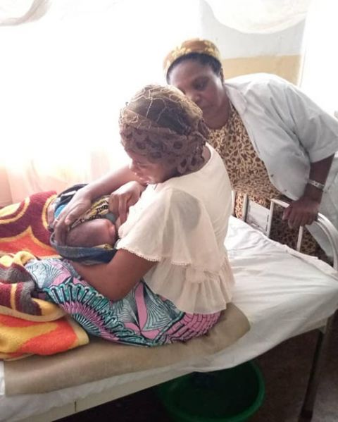 A nurse in a Daughters of the Resurrection clinic assists a new mother with breastfeeding her infant. (Courtesy of Rose Namulisa Balaluka)