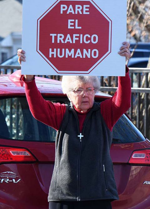Holy Union Sr. Maryellen Ryan holds up a "Stop Human Trafficking" sign at a January 2020 prayer vigil that took place at the motherhouse of the Sisters of St. Joseph in Brighton, Massachusetts, and was hosted by Boston's Anti-Trafficking Coalition.