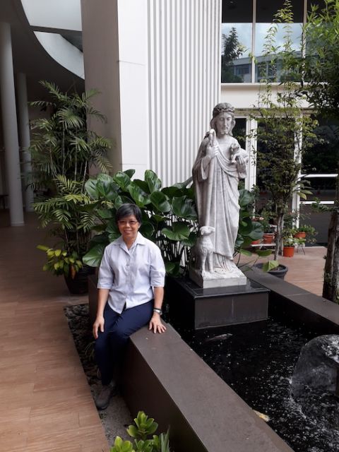 Good Shepherd Sr. Agnes-Claire Koh sits outside by the Good Shepherd statue in front of the chapel (Provided photo)