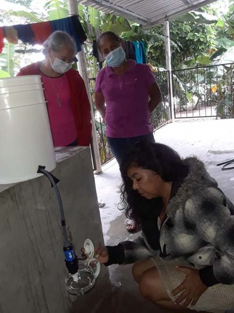 Maria Romero, a Congregation of Notre Dame associate, center, standing, demonstrates how to use a water filtration system to women in a community near Santa Barbara, Honduras, following the hurricanes. Clean drinking water is a priority in the disaster-hi Maria Romero, a Congregation of Notre Dame associate, center, standing, demonstrates how to use a water filtration system to women in a community near Santa Barbara, Honduras, following the hurricanes. Clean drinking water is a priority in the disaster-hi