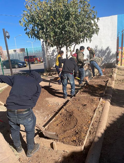 Migrants help out at the resource center's garden in October 2021. Normally, their stays at the center in Agua Prieta, Mexico, are brief, long enough to rest, eat and decide on their next steps after being returned to Mexico. (Peter Tran)