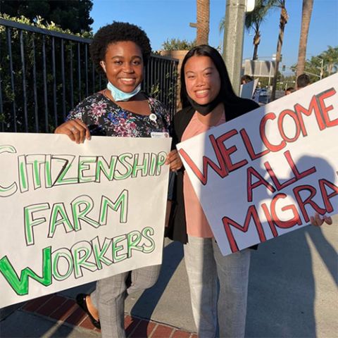 Cindy Emenalo, left, and Jaesen Evangelista. Cindy and I held homemade signs at the "Public Witness" event in Orange, California. (Courtesy of the Sisters of St. Joseph)