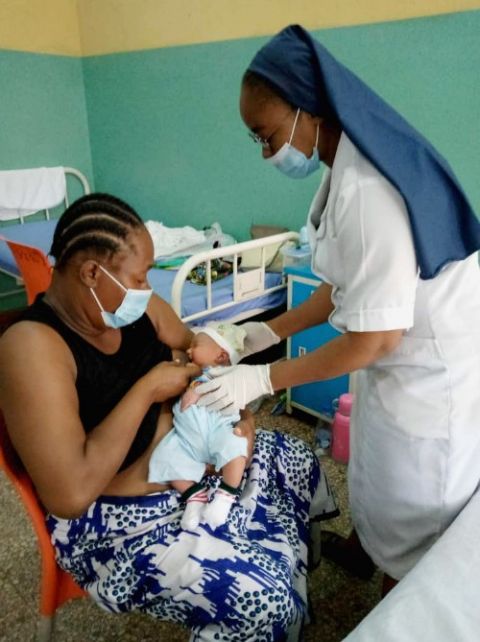 Notre Dame de Namur Sr. Agnes Enyi checks up on a nursing mother and her baby at St. Catherine of Siena Medical Centre in Lagos, Nigeria. (Patrick Egwu)