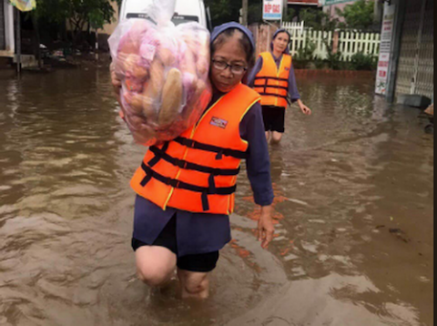 Sr. Anna Tran Thi Hien carries a bag of bread on her shoulder to deliver people in Dong Ha City on Oct. 23. (Joachim Pham)