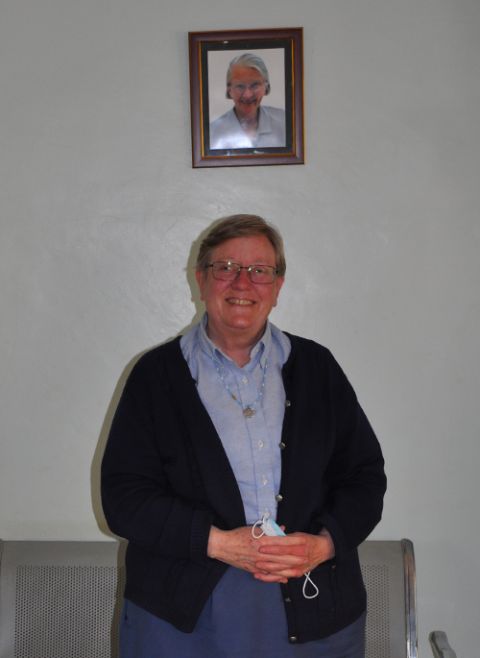 Sr. Deborah Mallott stands in the reception of Our Lady's Hospice-Thigio. Behind her is a photo of the later Sr Eileen O'Callaghan, who spent her last days at the hospice. (Lourine Oluoch)