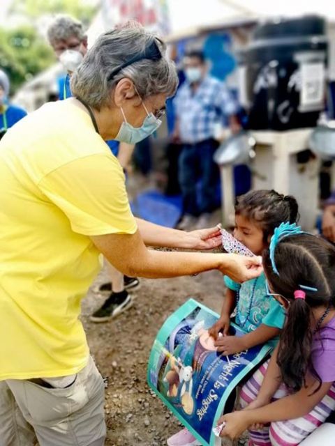Ursuline Sr. Jacinta Powers puts a mask on a child at the migrant camp in Matamoros, Mexico, so the girl could go to school. (Courtesy of Jacinta Powers)