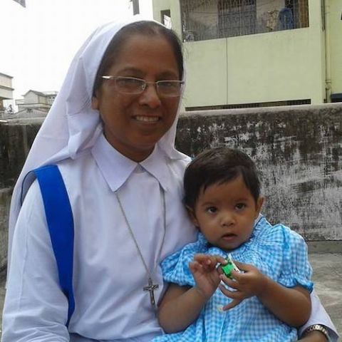 Habited Catholic sister holding a toddler in her lap