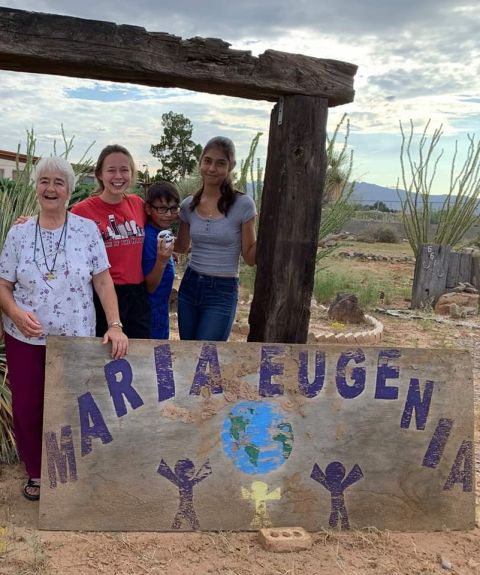 From left: Sister Chabela, Samantha Kominiarek, and Chaparral youth Oscar and Melenie in front of the Casa Maria Eugenia sign after an afternoon of playing in the yard (Provided photo)