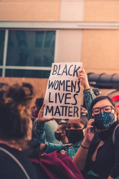 A protester holds up a sign at a protest in Chicago. (Photo by Max Bender on Unsplash)