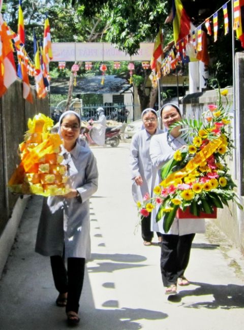 Daughters of Mary of the Immaculate Conception bring flowers and cakes wrapped in yellow paper to visit Hai Duc Pagoda in Hue City on May 6, the day before the Vesak festival to celebrate the birth of Buddha. (Joachim Pham)