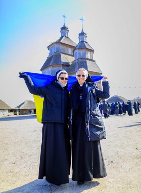 Basilian Srs. Yeremiya Steblyna, right, and Khryzanta Burmei proudly carry the Ukrainian flag at the monastic pilgrimage on the island of Khortytsia, in Zaporizhzhia. The pilgrimage finished just before Russia invaded Ukraine. (Yeremiya Steblyna)