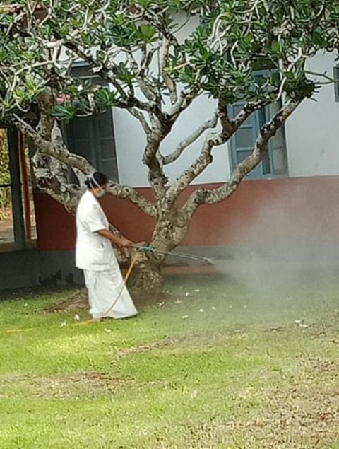 Medical Mission Sr. Annie Vettukattil, nursing superintendent, sanitizes the surroundings of Immaculate Heart of Mary Hospital in Kerala, India, in the absence of ground maintenance staff. (Courtesy of Mini Amalolbhavam)