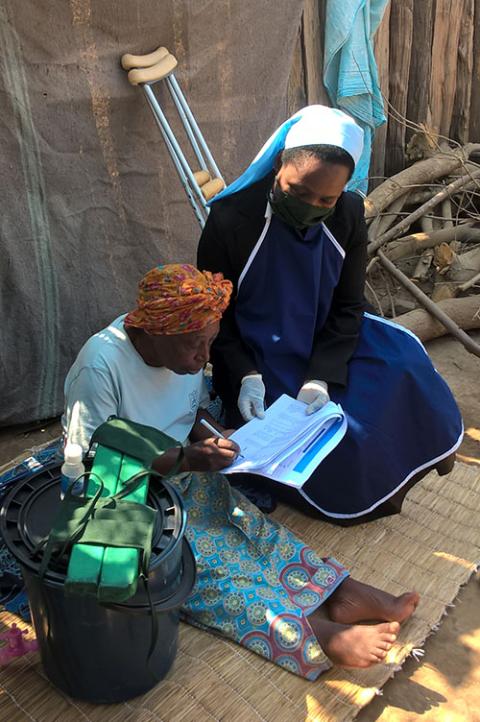 Carmelite Sr. Mildness Chinake visits with an elderly woman at the Tongogara Refugee Camp in Zimbabwe. Her ministry with Jesuit Refugee Service includes offering psychosocial support. (Courtesy of Mildness Chinake)