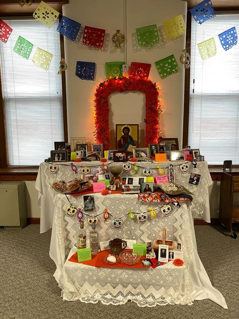 A Day of the Dead altar covered with photographs, food and other trinkets