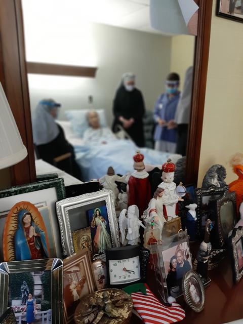 Little Sisters of the Poor sit with a woman who is dying in Washington in 2021. (Courtesy of the Little Sisters of the Poor)