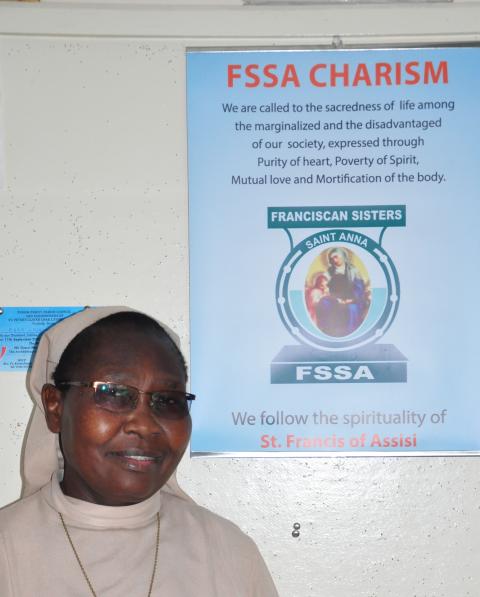 Sister stands in front of poster defining her order's charism.