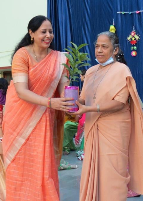 Biology teacher Sangeetha Madan gifts Sister Rupa, an Ursuline Sister of Mary Immaculate, with a sapling, motivating students at Mariampur School in Kanpur, India, to live sustainably in harmony with nature. (Courtesy of Tisy Jose)