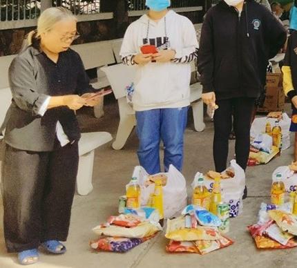 Sr. Cecilia Pham Thi Nhuong provides goods to young people (cropped for identity). (Mary Nguyen Thi Phuong Lan)