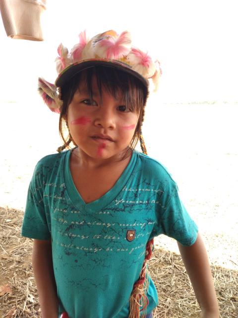 Una niña de los pueblos Guarani-Kaiowa con un penacho colorido y con el rostro pintado. 