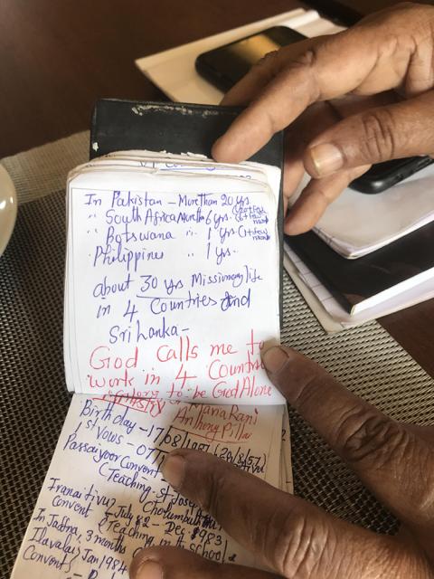 Holy Family Sr. Maria Rani Anthony Pillai, who serves as a conflict counselor in Jaffna, Sri Lanka, flips through a short diary with her missionary milestones from the past 40 years. (Thomas Scaria)