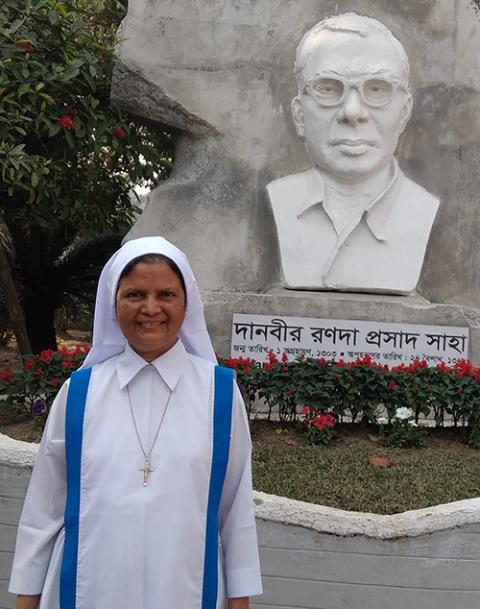 Sr. Mary Rina Magdeline Cruze poses in front of a sculpture of R.P. Shaha, the Hindu founder of Kumudini Nursing College, in March. (Sumon Corraya)