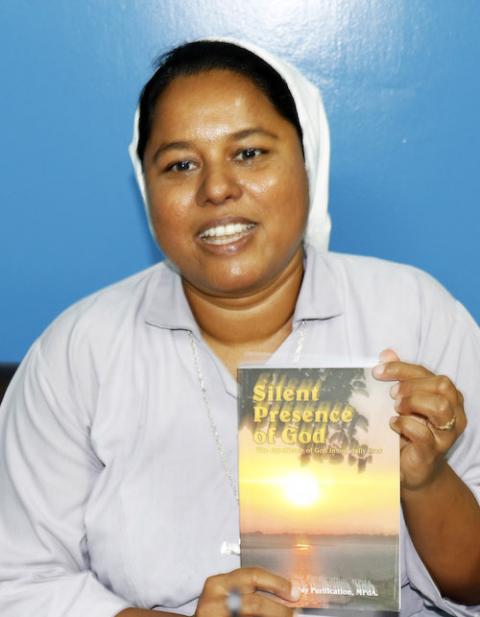 Our Lady of Sorrows Sr. Shibly Carmel Purification shows her recently published book, Silent Presence of God. (Uttom S. Rozario)