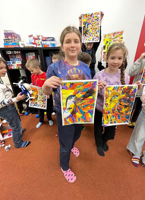 Children show off their artwork at a day care at the Caritas center in Warsaw, Poland. (Courtesy of David Bonior)