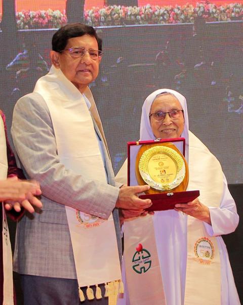 Sister Mary Lillian receives an honor for her lifelong contributions to CJW from Bangladesh's minister of textiles and jute, Golam Dastagir Gazi. (Sumon Corraya)