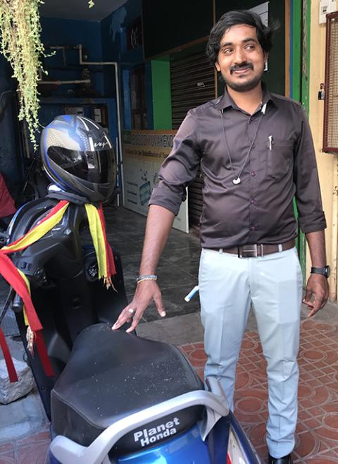 Veeresh, a former resident of BOSCO Yuvakendra in Bengaluru, southern India, where he now works as a screen-printing instructor, proudly shows his motorbike. (Thomas Scaria)