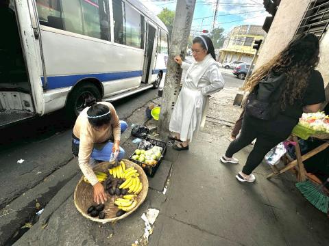 La Hna. Silvia Flores habla con una señora que vende fruta, el 25 de enero de 2024, sobre el nuevo proyecto —Sembrando Semillas de Esperanza— de Colegio Eucarístico dirigido por las Hermanas Mercedarias del Santísimo Sacramento en San Salvador, El Salvador. (Foto: GSR/ Rhina Guidos)