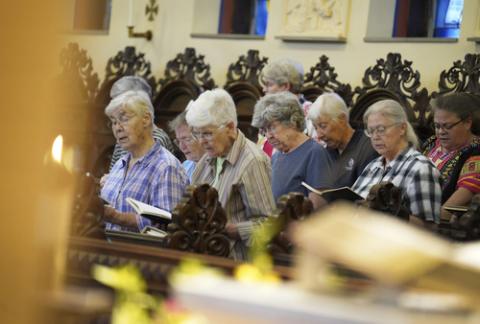 Sisters of Mount St. Scholastica in evening prayer, Atchison, Kansas, July 16, 2024. The sisters in choir rows, praying from books.