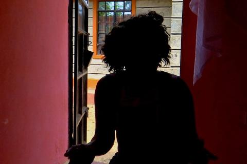 MUjer se asoma, de espaldas, a una ventana. En esta foto ilustrativa se ve a una presunta víctima de la trata de seres humanos. (Foto: CNS/ Jackson Njehia, Reuters/OSV News)