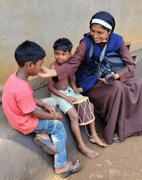 Sr. Lismy Parayil interacts with children while holding her camera. (Courtesy of Lismy Parayil) Sr. Lismy Parayil interacts with children while holding her camera. (Courtesy of Lismy Parayil)