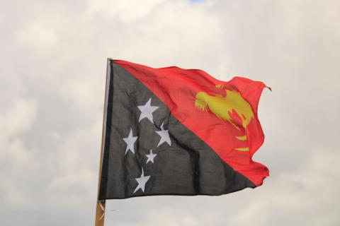 (Unsplash/Spencer Wungin) Photo of the flag of Papua New Guinea being blown by the wind.