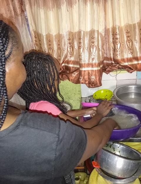 Anne Mutiso does some household cleaning, assisted by her oldest child. Eight months pregnant and with constant droughts in Makueni, Kenya, she has to manage the little water available. (Gitonga Njeru)