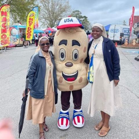 Sr. Imelda Ngwitu (left) and Sr. Ancilla Abonyo pose with a character representing the Blakely, Georgia, area's claim to fame: the peanut. (Courtesy of Dorann Cobb)