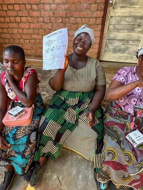 A woman in Malawi who recently received a Watts of Love solar light and financial literacy training displays her empowerment form, outlining her plan to save money previously spent on batteries and invest in livestock, with the long-term goal of buying a home for her family, during a four-day session at Mponela Lodge in Malawi in October 2025. (Courtesy of Watts of Love)