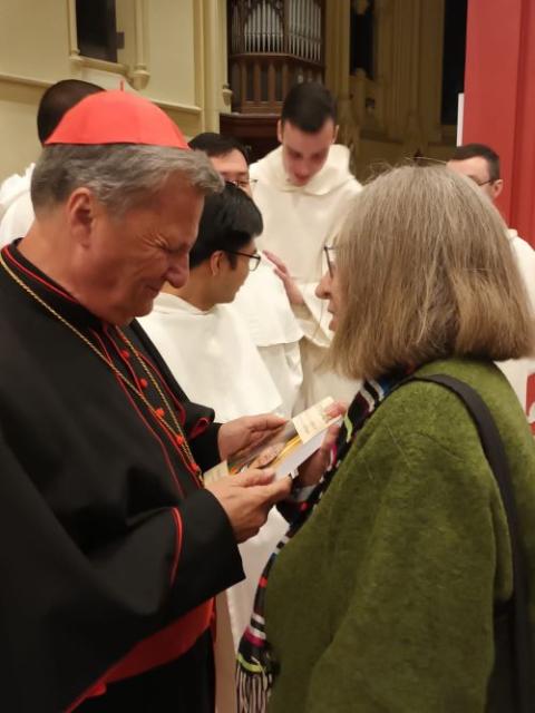 Soline Humbert presents a copy of her book "A Divine Calling: One Woman's Life-Long Battle for Equality in the Catholic Church" to Cardinal Mario Grech of Malta. Grech is  secretary-general of the Synod of Bishops. (Courtesy of Soline Humbert)
