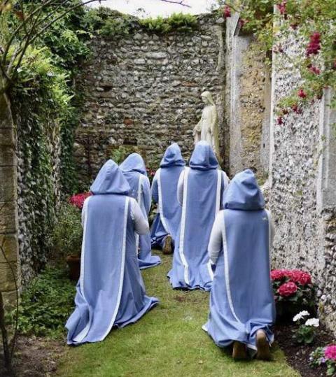 Sisters of the Community of Our Lady of Walsingham kneel in prayer at the site of what was the chapel for the Franciscan Friary in Walsingham, England. (Courtesy of Community of Our Lady of Walsingham)