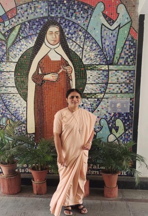 Sr. Maria Nirmalini, superior general of the Apostolic Carmel congregation in India, stands in front of a portrait of her community's founder, Mother Veronica of the Passion, at the generalate in Bengaluru. (Thomas Scaria)