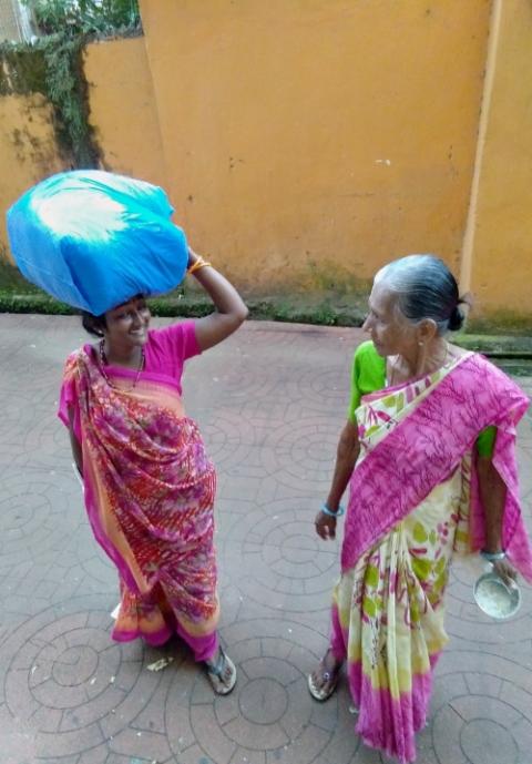 A migrant woman selling waste papers collected from shops stops to converse with another woman in the city center of Panaji, in Goa, western India. (Lissy Maruthanakuzhy) A migrant woman selling waste papers collected from shops stops to converse with another woman in the city center of Panaji, in Goa, western India. (Lissy Maruthanakuzhy)