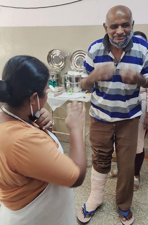Sr. Fathima Mary Lourdraj works with a resident of the Sumanahalli rehabilitation center after his legs were bandaged. (Thomas Scaria)