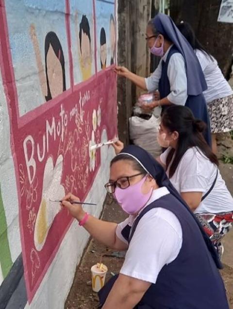 Holy Spirit Sisters help paint the mural on their convent wall. (Provided photo)