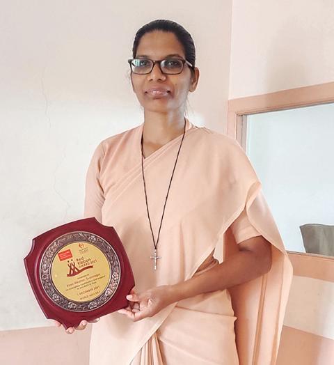 Holy Family of Nazareth Sr. Phileshin D'Souza receives the Red Ribbon Award for the Kiran Niketan Social Centre's work with children and adolescents living with HIV. (Courtesy of Molly Fernandes)