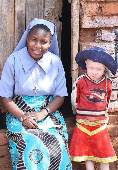 Teresian Sr. Teresa Mulenga sits with one of the Masautso children at their front door in Mtendere, Malawi. (GSR photo/Doreen Ajiambo)