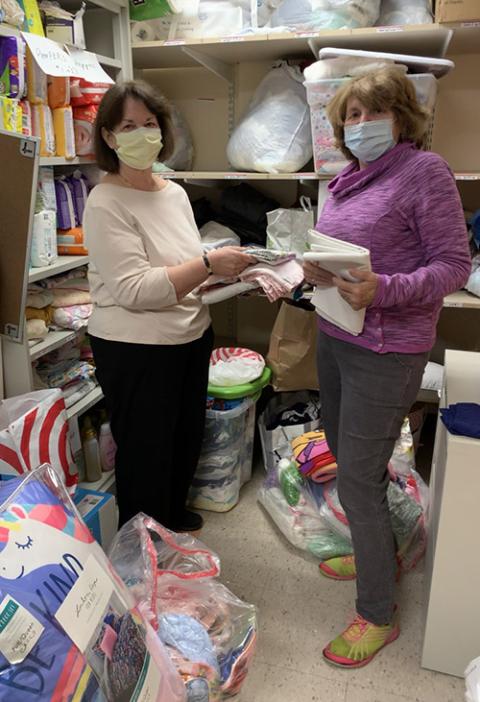 Sisters of St. Joseph of Boston associates Kathie Shute, left, and Kathy Tighe prepare donated baby items before the arrival of Afghan refugees to the Boston area. (Courtesy of Sisters of St. Joseph of Boston)