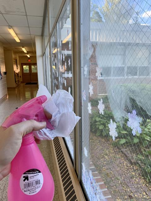 Cleaning a window at Collier High School to prepare for the next season (Maddie Thompson)