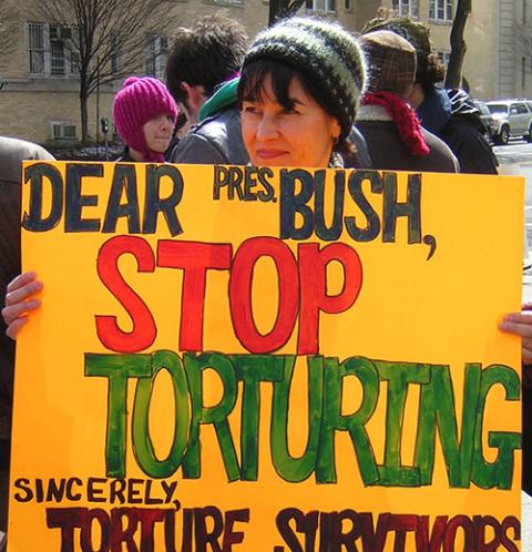 Ursuline Sr. Dianna Ortiz holds a sign for then-president George W. Bush during a 2007 anti-torture vigil by Torture Abolition and Survivors Support Coalition members in Washington, D.C. (Courtesy of the Ursuline Sisters of Mount St. Joseph)